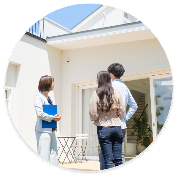 自宅前で家を見上げながら相談する様子